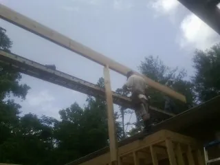 Carpenter setting a ridge beam over a new addition frame — Ice Dam Removal by Roofing Brothers in Pine Valley